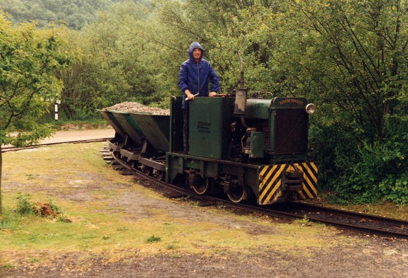 blue-star-skips.jpg - Even in the rain work has to go on to keep our track up to standard. The Blue Star Hudson Hunslet hauls a train of skips loaded with track ballast around the triangle.